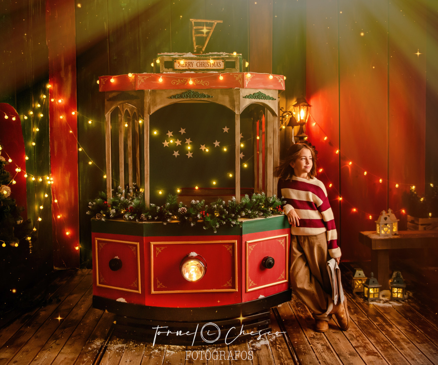 Niño en un tranvia navideño decorado.